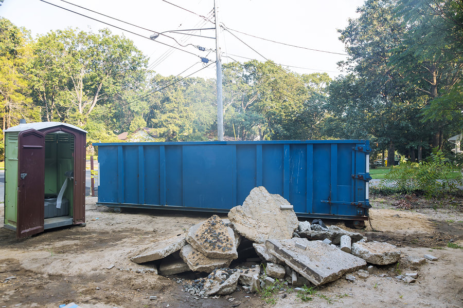 blue dumpster and portable restroom
